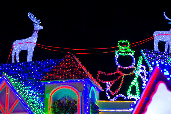 Night view of a fake house with Christmas lights, reindeer figure and snowman in the Iberoamerican Park, Santo Domingo, Dominican Republic.